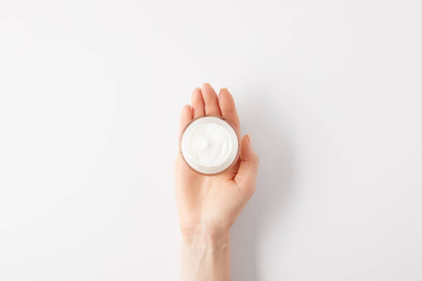 cropped image of woman holding organic cream in container 