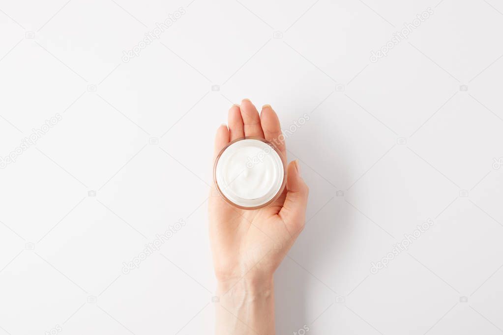 cropped image of woman holding organic cream in container 