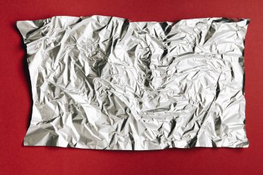 close-up view of empty crumpled foil texture on dark red background clipart