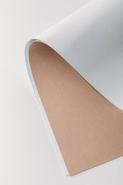 close-up view of white and brown rolled paper sheets on grey background  