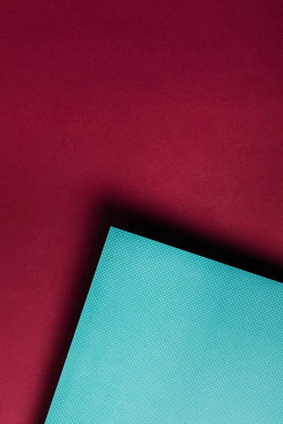 汚れたあずき色背景に創造的なターコイズ色紙  — 無料ストックフォト