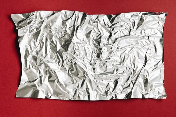 Närbild Tom Skrynkliga Aluminiumfolie Konsistens Mörk Röd Bakgrund — Stockfoto
