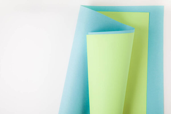blue and green paper sheets on grey background