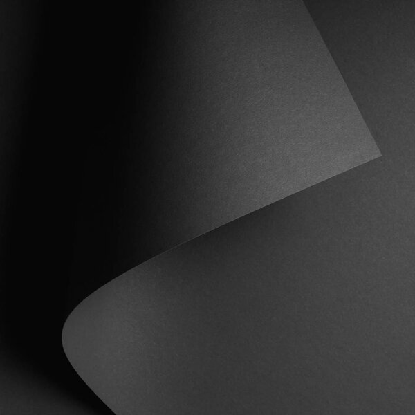 dark abstract background with black rolled paper sheet