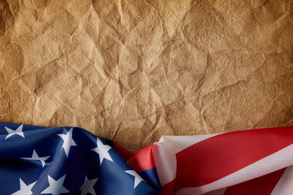 top view of old crumpled paper and united states flag