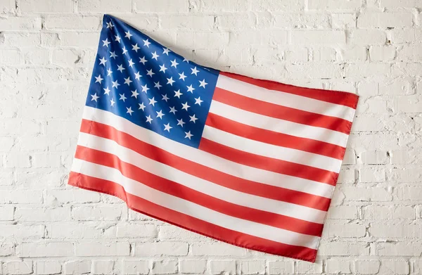 美国国旗贴在白色砖墙上的特写镜头 — 图库照片