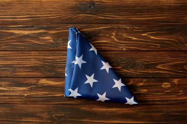 在木表面上折叠的美国旗子的上升的看法 — 图库照片