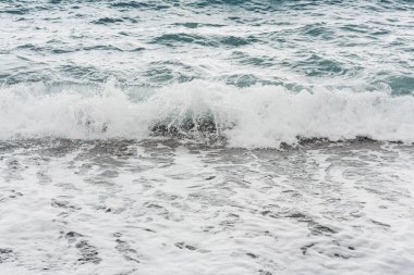 Dalgalar yazın deniz kıyısına vurur. 