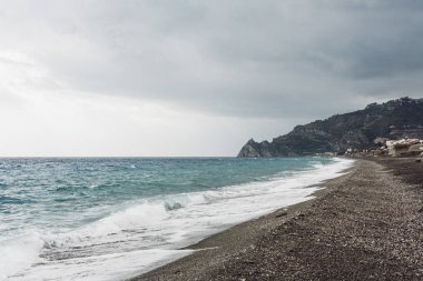 Deniz dalgaları sahilin kumlu sahillerine vuruyor. 
