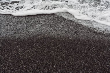 Islak kumsalda beyaz deniz köpüğü 