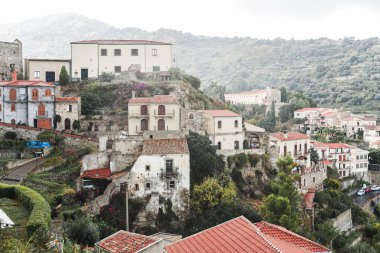 Sicilya 'daki ağaçların ve bitkilerin yakınındaki tepelerde küçük evler 