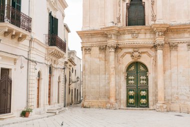 Scicli, İtalya - 3 Ekim 2019: İtalya 'daki binaların yakınlarındaki San Michele Arcangelo Kilisesi' nin barok cephesi 