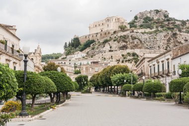 Scicli, İtalya - 3 Ekim 2019: Eski kilisenin ve Sicli 'deki binaların yakınında kaldırım taşları olan cadde 