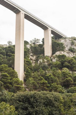 Modica, İtalya - 3 Ekim 2019: Sicilya 'da yeşil bitki ve ağaçların yakınında modica viyadük 