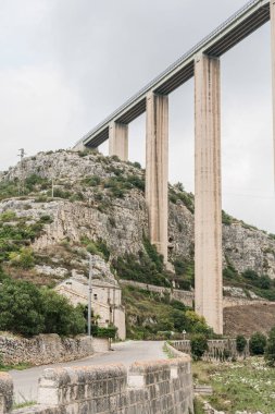 MODICA, ITALY - OCTOBER 3, 2019: modica viaduct near green plants road in Sicily  clipart