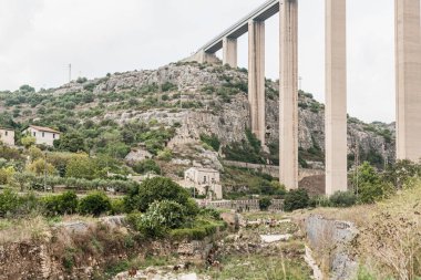 Modica, İtalya - 3 Ekim 2019: Sicilya 'da yeşil bitki ve ağaçların yakınında modica viyadük 