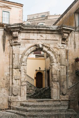 ancient arch in old building in modica, italy  clipart
