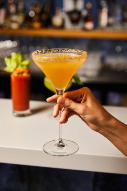 Margarita bardağıyla kokteyl içen kadının seçici odağı.