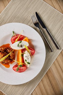 Patlıcan havyarlı ve ahşap masada servis edilen domatesli leziz restoran yemeklerinin üst görüntüsü.