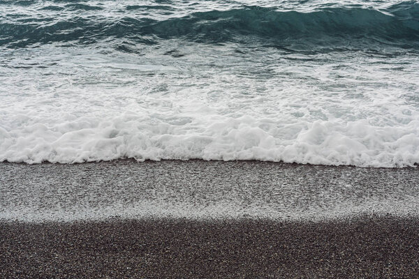 sea waves splash on sandy beach in summer 