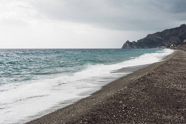 waves splash of sea on sandy beach in coastline 
