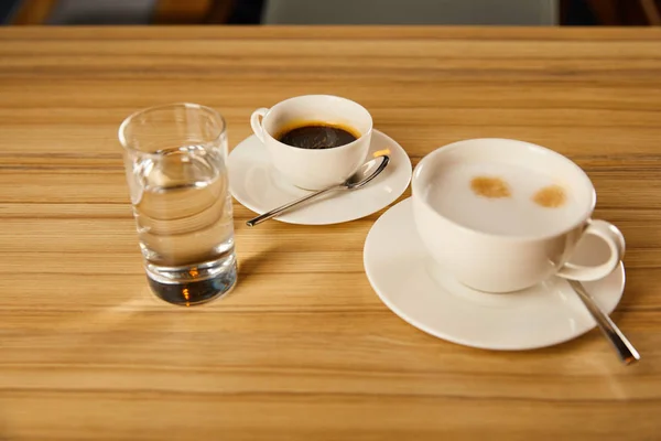 Kopjes Met Koffie Bij Glas Water Café — Stockfoto