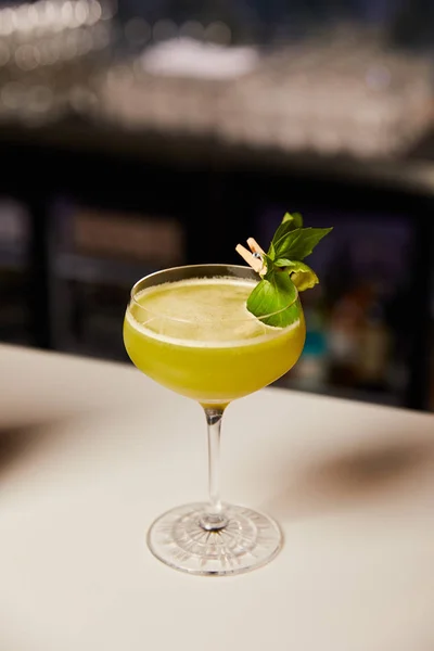 glass with sour alcohol cocktail on bar counter