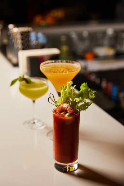 selective focus of cold bloody mary cocktail in glass on bar stand