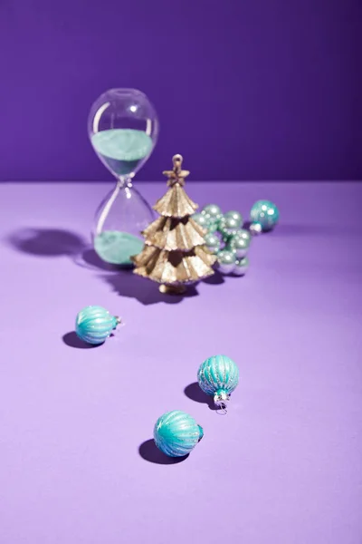 Foco Seletivo Natal Decorativo Perto Bugigangas Azuis Ampulheta Fundo Roxo — Fotografia de Stock