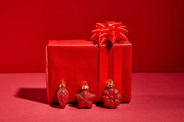 Caixa Presente Festivo Envolto Vermelho Com Bugigangas Fundo Vermelho — Fotografia de Stock