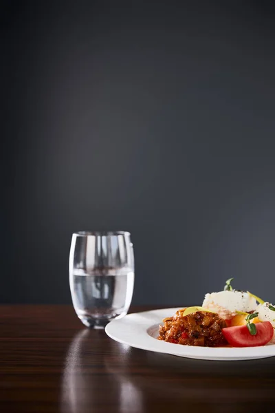 黒を基調とした木のテーブルの上にナスキャビアとトマトのおいしいレストラン料理 — ストック写真