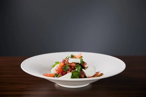 Heerlijk Restaurant Salade Met Kaas Geserveerd Witte Plaat Houten Tafel — Stockfoto