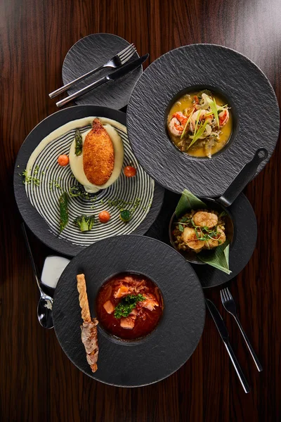 Top view of delicious restaurant dishes with cutlery on wooden table — Stock Image Top View Delicious Restaurant Dishes Cutlery Wooden Table Stock Image