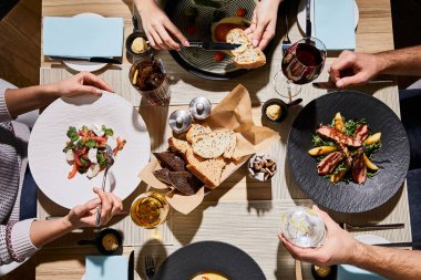 top view of people eating delicious food during dinner in restaurant  clipart