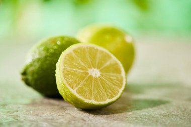 Bütünün seçici odak noktası ve mermer yüzeydeki damlalarla limonları kes 