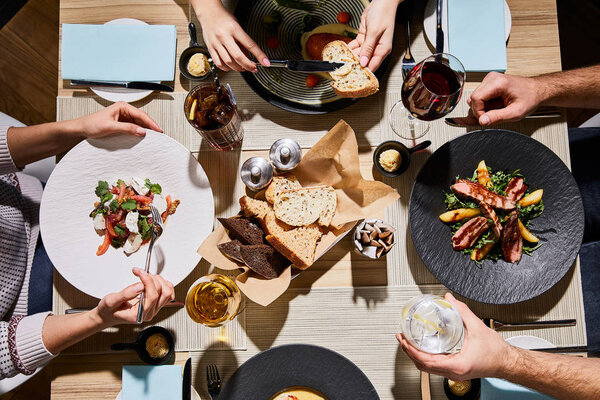 top view of people eating delicious food during dinner in restaurant 