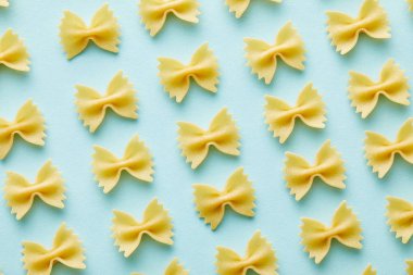 düz mavi arkaplan üzerinde ham Farfalle ile yatıyordu
