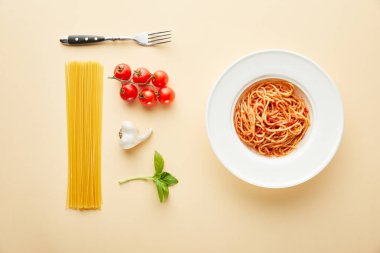 flat lay with delicious spaghetti with tomato sauce in plate near fork and ingredients on yellow background clipart