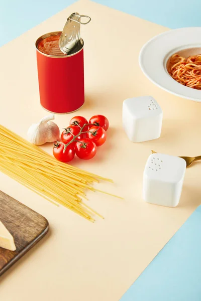 Espaguete Delicioso Com Molho Tomate Prato Perto Ingredientes Fundo Azul — Fotografia de Stock
