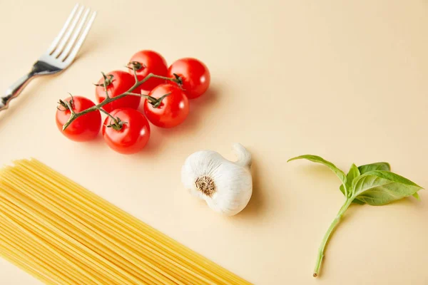 Surowe Spaghetti Czosnek Pomidory Bazylia Widelec Żółtym Tle — Zdjęcie stockowe