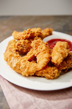 close up view of delicious chicken nuggets with ketchup on stone surface clipart