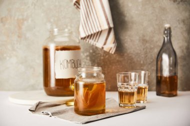 Kombu çayı bardakların yanında şeritli peçeteli gri arkaplanda seçici odak noktası