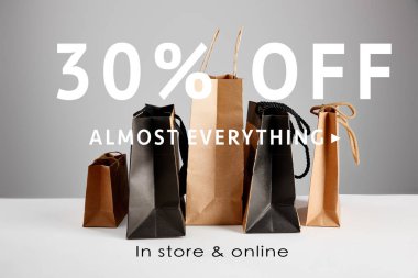 paper shopping bags isolated on grey with 30 percent off almost everything illustration, black Friday concept clipart