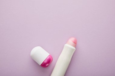 Menekşe arkaplanda deodorant şişelerinin üst görünümü