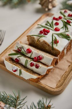 Geleneksel Noel pastası, beyaz masadaki ahşap tahtada kızılcık.