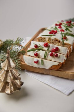 Geleneksel Noel pastasının seçici odak noktası yaban mersinli, mücevherli ve mermer masadaki çamlı gri.