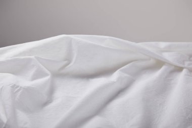 Kırışmış beyaz kumaş, kopyalama alanı olan gri renkte izole edilmiş.