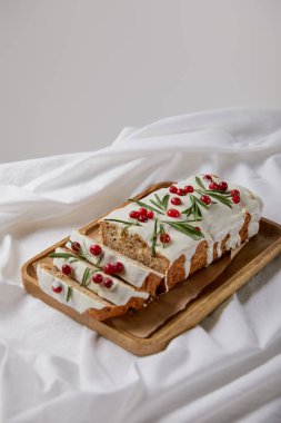 Geleneksel Noel pastası, ahşap tahtada kızılcık, beyaz kumaşta gri renkte izole edilmiş.