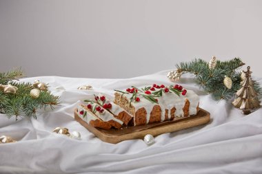 Geleneksel Noel pastası, ahşap tahtada yaban mersini, gümüş mücevherlerin yanında ve gri çamlı.