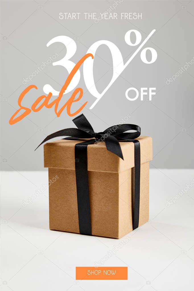 cardboard gift box with black ribbon isolated on grey with sale 30 percent off, black Friday concept
